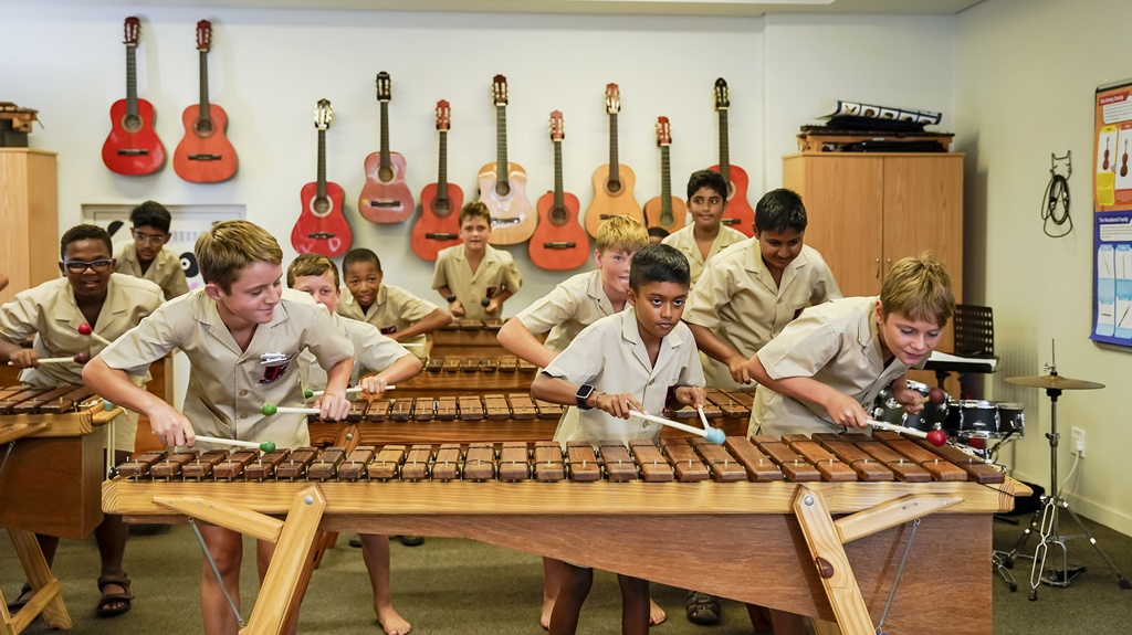 At Clifton, the musical journey begins in grade 00 and goes all the way through the school to grade 12. The guitars hanging on the wall in the photo are all made available to the boys to learn during their primary school years.