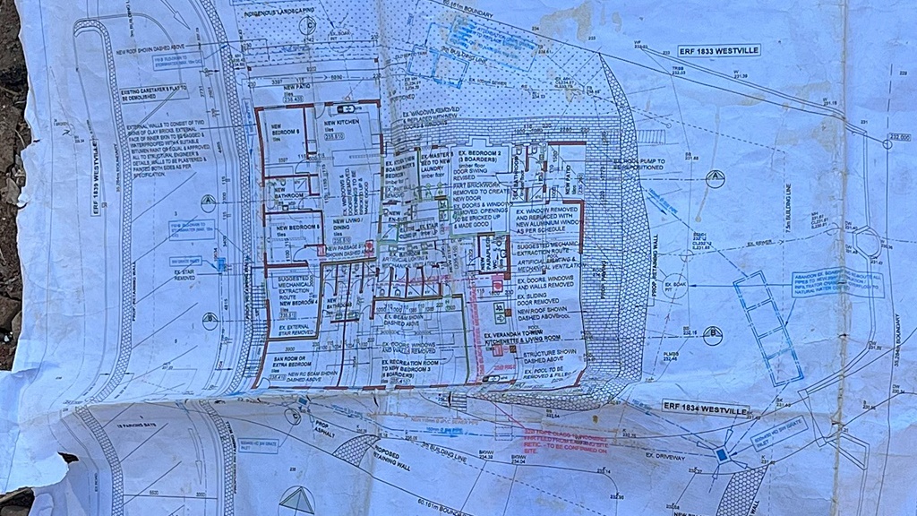 Lying atop some rubble on the building site, the plans for Westville's impressive new boarding house.