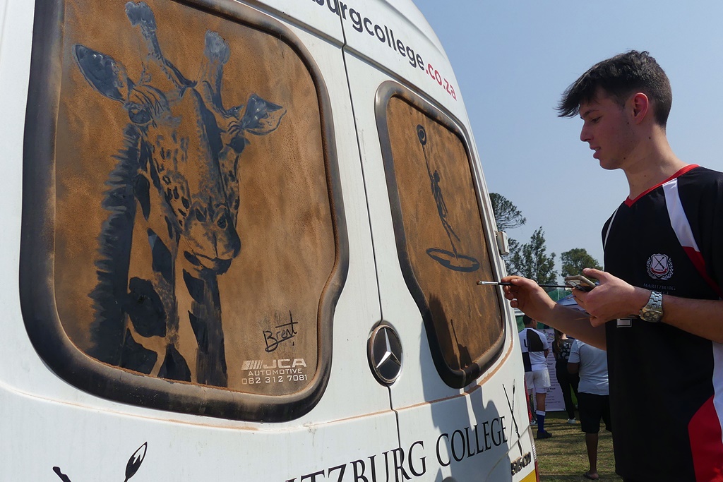 After adding a giraffe to the back of a College bus, Brent Gademan then drew the Jimeloyo Ji fountain statue. (Photo: Brad Morgan) 