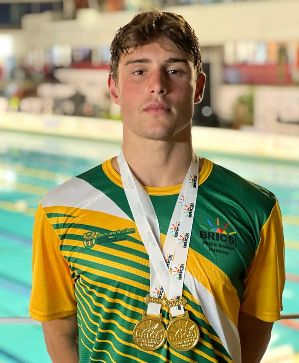 Wearing the green and gold of South Africa, Luca Sandri shows off the two gold medals he won at the BRICS Games.